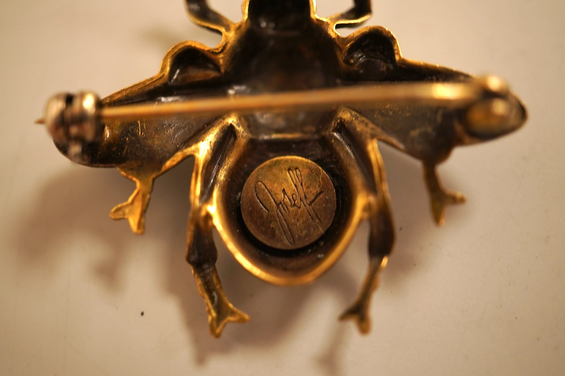 A mid 20th century North American gilt metal bee brooch by Joseff, wing span 30mm, together with a hard back copy of 'Jewelry of the Stars, Creations from Joseff of Hollywood' by Joanne Dubbs Ball.